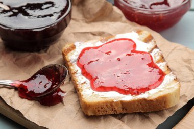 tost reçelli. Mavi ahşap bir masa üzerinde kırmızı reçel ile kızarmış gevrek ekmek. Kahvaltı. yakın çekim