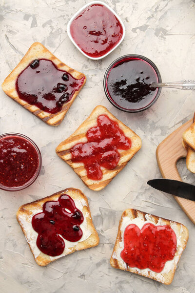 toasts with jam. fried crispy toasts with red jam on a light concrete table. breakfast. top view