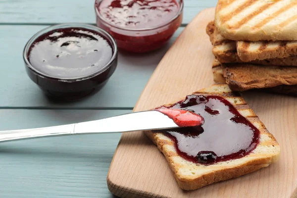 toasts with jam. fried crispy toast with red jam on a blue wooden table. breakfast.