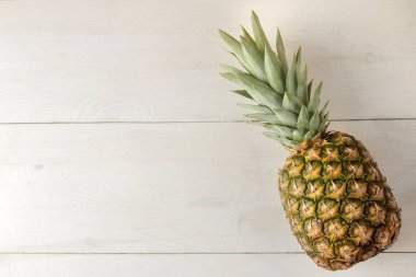 Beyaz ahşap bir masada olgun ananas meyve. Yaz. üst görünüm. metin için alan