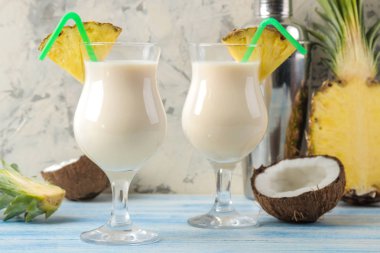Kokteyl Pina Colada. Pina Colada hindistan cevizi sütü ve ananas suyu ile yaz alkollü kokteyl yakındaki. yaz içkisi. kokteyl hazırlığı. açık bir arka plan ve mavi bir masada.