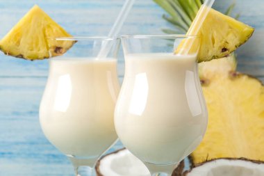 Kokteyl Pina Colada. Pina Colada hindistan cevizi sütü ve ananas suyu ile yaz alkollü kokteyl yakındaki. yaz içkisi. kokteyl hazırlığı. mavi ahşap arka plan üzerinde.