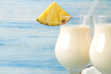 Kokteyl Pina Colada. Pina Colada hindistan cevizi sütü ve ananas suyu ile yaz alkollü kokteyl yakındaki. yaz içkisi. kokteyl hazırlığı. mavi ahşap arka plan üzerinde. Close