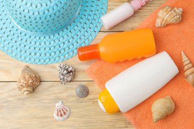 Güneş. doğal ahşap arka plan üzerinde çeşitli güneş kremleri ve plaj, yaz aksesuarları. Yaz. Tatil. Güneş koruması. üst görünüm