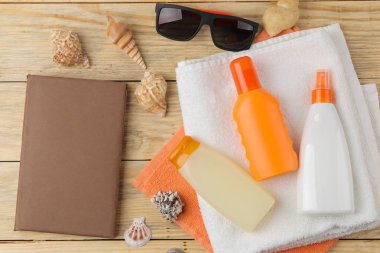 Güneş. doğal ahşap arka plan üzerinde çeşitli güneş kremleri ve plaj, yaz aksesuarları. Yaz. Tatil. Güneş koruması. üst görünüm