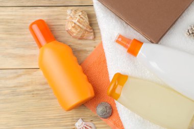 Güneş. doğal ahşap arka plan üzerinde çeşitli güneş kremleri ve plaj, yaz aksesuarları. Yaz. Tatil. Güneş koruması. üst görünüm