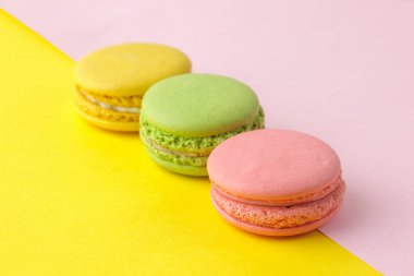 Macaronlar. fransız çok renkli macaroons kek. parlak çok renkli pembe ve sarı arka plan üzerinde küçük fransız tatlı pasta. Tatlı. Tatlı.