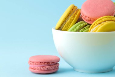 Macaronlar. bir fincan fransız çok renkli macaroons kek. parlak mavi arka plan üzerinde küçük fransız tatlı pasta. Tatlı. Tatlı.