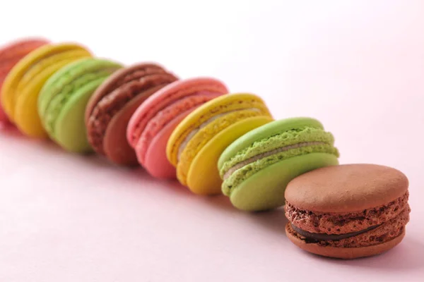 Macarons. french multicolored macaroons cakes. small french sweet cake on bright pink background. Dessert. Sweets.