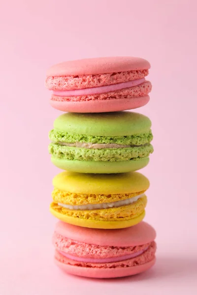 Macarons. french multicolored macaroons cakes. small french sweet cake on bright pink background. Dessert. Sweets.