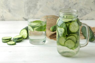 salatalık ile su. Hafif bir arka plan üzerinde bir cam bardak salatalık ile ferahlatıcı diyet suyu. detoks içecek kavramı. yaz serinletici içecek.