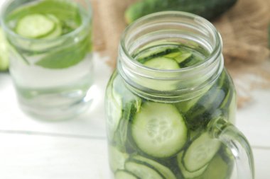 salatalık ile su. Hafif bir arka plan üzerinde bir cam bardak salatalık ile ferahlatıcı diyet suyu. detoks içecek kavramı. yaz serinletici içecek.