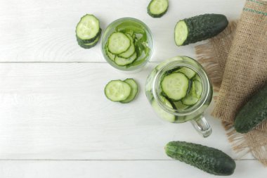 salatalık ile su. Hafif bir arka plan üzerinde bir cam bardak salatalık ile ferahlatıcı diyet suyu. detoks içecek kavramı. yaz serinletici içecek. üst görünüm