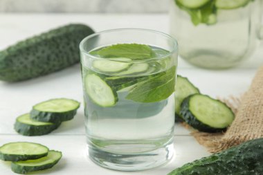 salatalık ile su. Hafif bir arka plan üzerinde bir cam bardak salatalık ile ferahlatıcı diyet suyu. detoks içecek kavramı. yaz serinletici içecek.