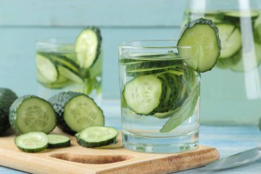 salatalık ile su. Mavi bir arka plan üzerinde bir cam beher salatalık ve nane ile ferahlatıcı diyet suyu. detoks içecek kavramı. yaz serinletici içecek.