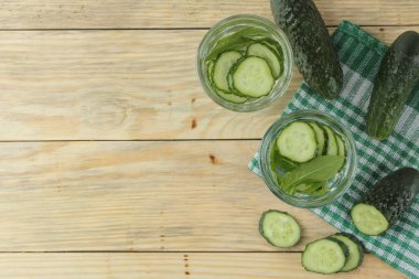 salatalık ile su. Ahşap bir arka plan üzerinde cam bir beher salatalık ve nane ile ferahlatıcı diyet suyu. detoks içecek kavramı. yaz serinletici içecek. üst görünüm