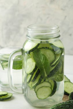 salatalık ile su. Hafif bir arka plan üzerinde bir cam bardak salatalık ile ferahlatıcı diyet suyu. detoks içecek kavramı. yaz serinletici içecek.