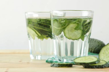 salatalık ile su. Ahşap bir arka plan üzerinde cam bir beher salatalık ve nane ile ferahlatıcı diyet suyu. detoks içecek kavramı. yaz serinletici içecek.