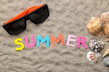 Çok renkli harfler ve deniz kabukları ve deniz kumu üzerinde yaz aksesuarları kağıt yazıt yaz. Yaz. Rahatlama. Tatil. üst görünüm