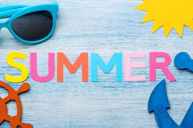 Çok renkli harfler ve deniz kabukları ve mavi ahşap bir masa üzerinde yaz ve deniz aksesuarları kağıt yazıt yaz. Yaz. Rahatlama. Tatil. üst görünüm