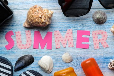 Çok renkli harfler ve deniz kabukları ve mavi ahşap bir masa üzerinde yaz ve deniz aksesuarları kağıt yazıt yaz. Yaz. Rahatlama. Tatil. üst görünüm