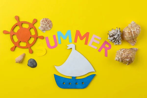 Inscription summer from paper of multi-colored letters and seashells and a ship on a bright yellow background. Summer. relaxation. vacation.