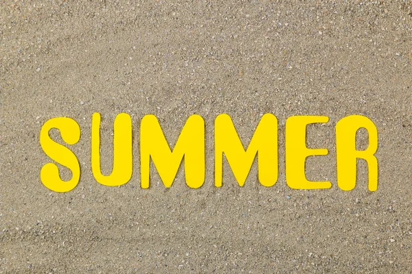 Inscription summer of paper yellow letters on the sea sand. Summer. relaxation. vacation. top view