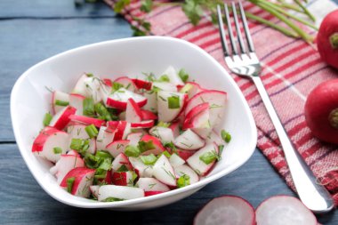 Mavi ahşap bir masada taze turp ve taze otlar Salatası. Bahar sebze salatası. pişirme salatası için malzemeler.