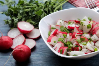 Mavi ahşap bir masada taze turp ve taze otlar Salatası. Bahar sebze salatası. pişirme salatası için malzemeler.