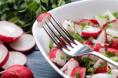 Mavi ahşap bir masada taze turp ve taze otlar Salatası. Bahar sebze salatası. pişirme salatası için malzemeler.