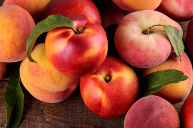 kahverengi ahşap bir arka plan üzerinde şeftali birçok çeşitleri kompozisyon. Meyve.