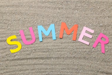 Yazıt yaz kağıt deniz kumu üzerinde çok renkli harfler. Yaz. Rahatlama. Tatil. üst görünüm