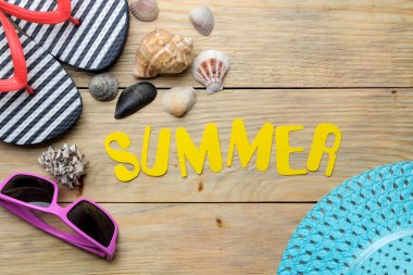 Kelime yaz kağıt sarı harfler ve yaz, doğal ahşap arka plan üzerinde plaj aksesuarları yapılmış. Yaz. Tatil. Rahatlama. üst görünüm