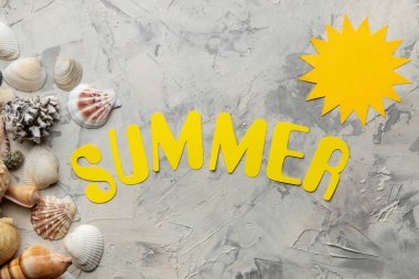 Kağıt sarı harfler ve deniz aksesuarları kelime yaz, hafif beton arka plan üzerinde kabukları. Yaz. Tatil. Rahatlama. üst görünüm.