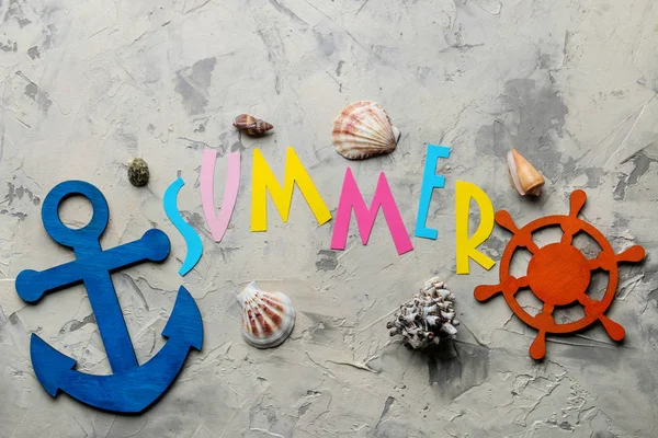 The word summer from paper with multicolored letters and sea accessories, shells on a light concrete background. summer. vacation. relaxation. top view