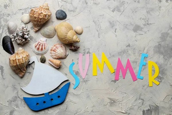 这个词夏天从纸与五颜六色的字母和海洋配件 贝壳在一个轻混凝土背景 顶部视图 — 图库照片