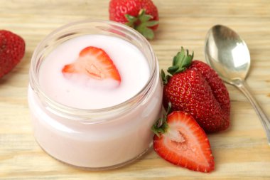 doğal bir ahşap masada bir kavanoz ve taze olgun çilek lezzetli çilek yoğurt