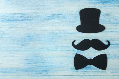 Babalar günün kutlu olsun. açık mavi ahşap arka plan üzerinde dekoratif erkek bıyık, şapka ve papyon. üst görünüm