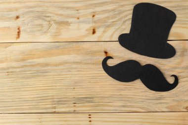 Babalar günün kutlu olsun. doğal ahşap arka plan üzerinde dekoratif erkek bıyık ve şapka. üst görünüm