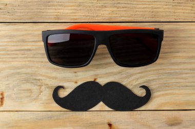 Babalar günün kutlu olsun. doğal ahşap arka plan üzerinde dekoratif erkek bıyık ve gözlük. üst görünüm