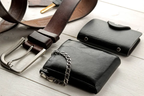 Men's Accessories.men's style. Glasses, business card holder, cigar, smartphone, notebook, headphones, and a pistol-lighter on a blue wooden background.