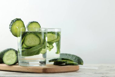 salatalık ile su. Hafif bir arka plan üzerinde bir cam bardak salatalık ile ferahlatıcı diyet suyu. detoks içecek kavramı. yaz serinletici içecek.