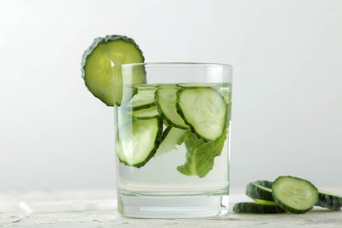 salatalık ile su. Hafif bir arka plan üzerinde bir cam bardak salatalık ile ferahlatıcı diyet suyu. detoks içecek kavramı. yaz serinletici içecek.