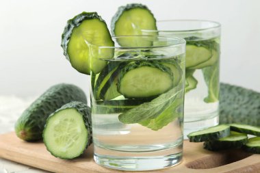 salatalık ile su. Hafif bir arka plan üzerinde bir cam bardak salatalık ile ferahlatıcı diyet suyu. detoks içecek kavramı. yaz serinletici içecek.