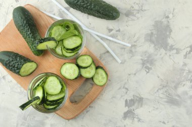 salatalık ile su. Hafif bir arka plan üzerinde bir cam bardak salatalık ile ferahlatıcı diyet suyu. detoks içecek kavramı. yaz serinletici içecek. üst görünüm