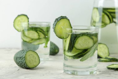 salatalık ile su. Hafif bir arka plan üzerinde bir cam bardak salatalık ile ferahlatıcı diyet suyu. detoks içecek kavramı. yaz serinletici içecek.