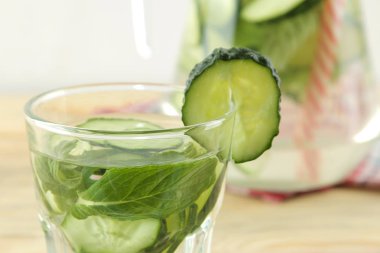 salatalık ile su. Mavi bir arka plan üzerinde bir cam beher salatalık ve nane ile ferahlatıcı diyet suyu. detoks içecek kavramı. yaz serinletici içecek. üst görünüm