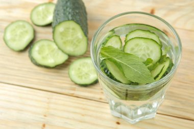 salatalık ile su. Mavi bir arka plan üzerinde bir cam beher salatalık ve nane ile ferahlatıcı diyet suyu. detoks içecek kavramı. yaz serinletici içecek. üst görünüm