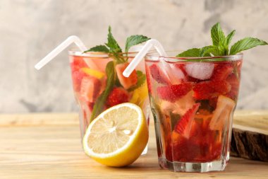 Çilek mojito. Doğal ahşap bir masa üzerinde bir bardak çilek, nane, limon ve buz ile soğuk yaz mojito kokteyl. yaz serinletici içecek.