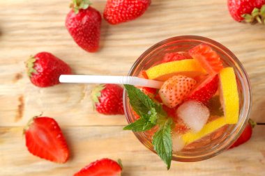 Çilek mojito. Doğal ahşap bir masa üzerinde bir bardak çilek, nane, limon ve buz ile soğuk yaz mojito kokteyl. yaz serinletici içecek. üst görünüm